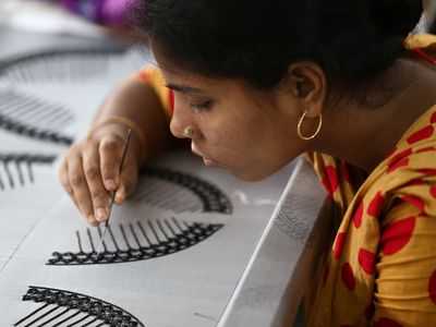 A female artisan concentrates on weaving