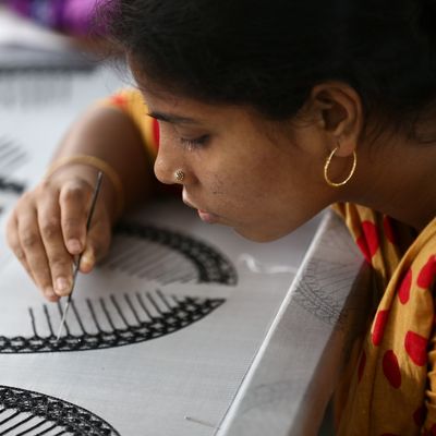 A female artisan concentrates on weaving