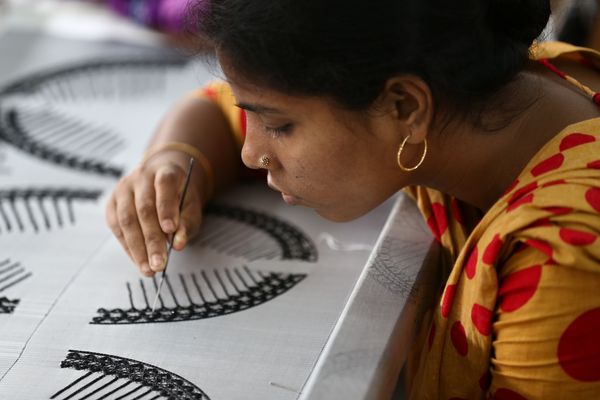 A female artisan concentrates on weaving