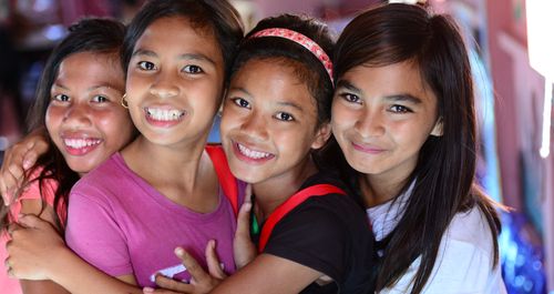 Four smiling girls hugging