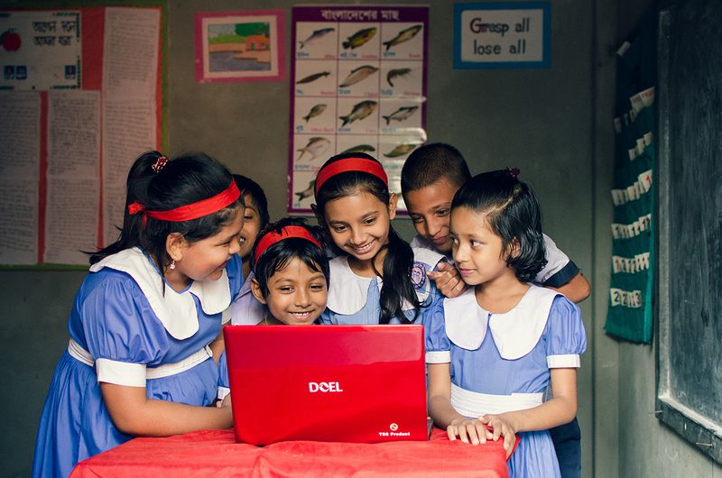Students gather around a laptop to access digital multimedia content.