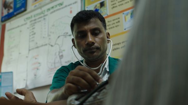 A paramedic checking the blood pressure of his patient in a community clinic in northern Bangladesh.