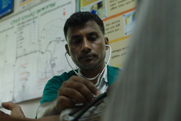 A paramedic checking the blood pressure of his patient in a community clinic in northern Bangladesh.