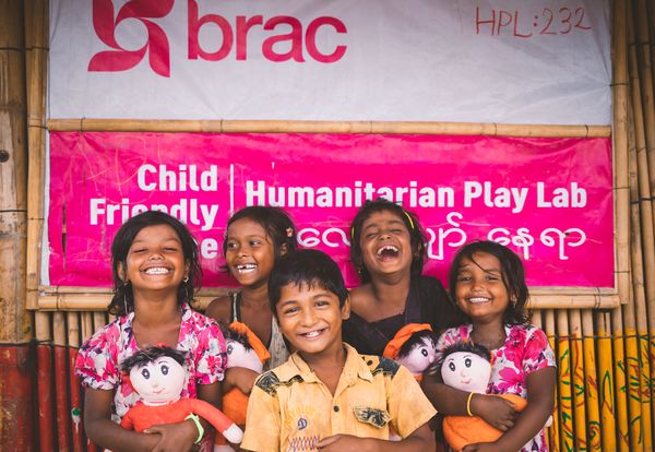 Rohingya refugee children standing in front of a humanitarian play lab in the camps in Cox's Bazar, Bangladesh