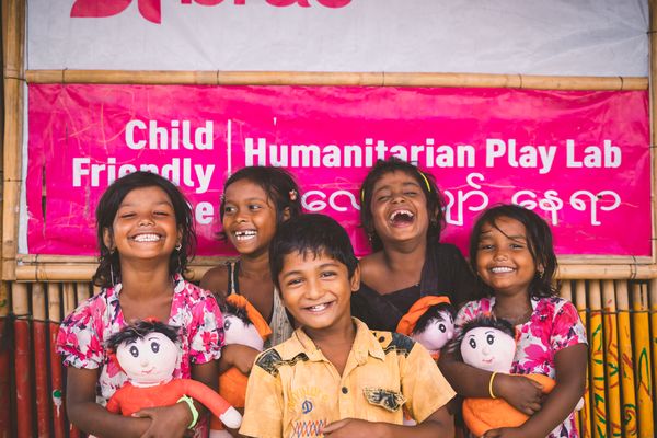 Rohingya refugee children standing in front of a humanitarian play lab in the camps in Cox's Bazar, Bangladesh
