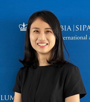 An Asian woman wearing a black tshirt smiles at the camera.
