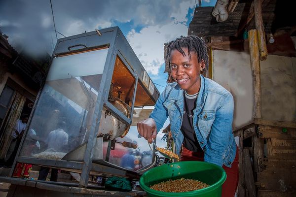 A young woman scooping popcorn kernals