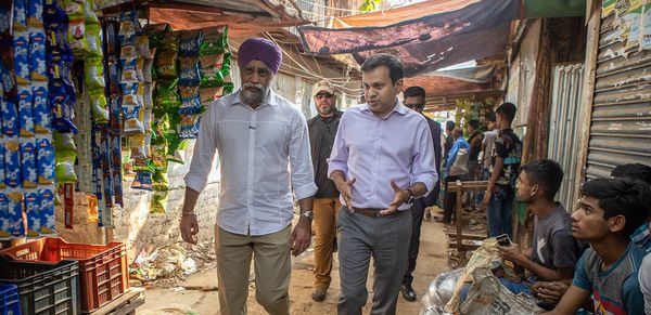 BRAC Executive Dictor Asif Saleh walking down the street of Karail, Bangladesh's biggest informal settlement, with former Minister of International Development of Canada Harjit S. Sajjan in 2023